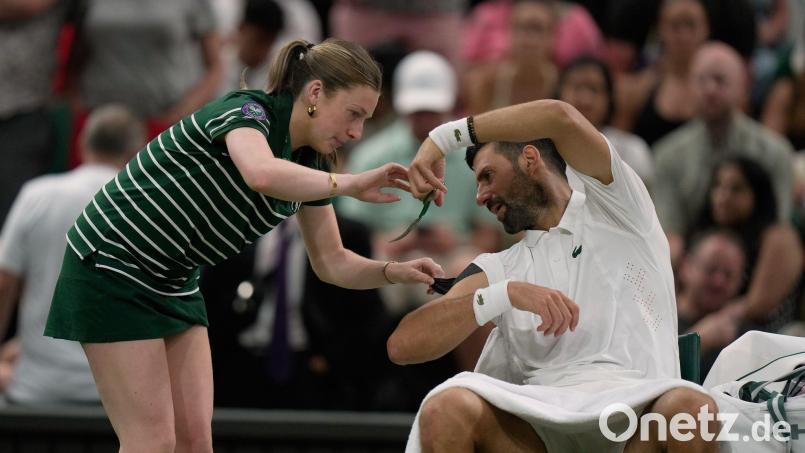 Novak Djokovic ließ sich von einem Ballmädchen helfen - und erschreckte sie für einen ganz kurzen Moment. Bild: Brian Inganga/AP/dpa
