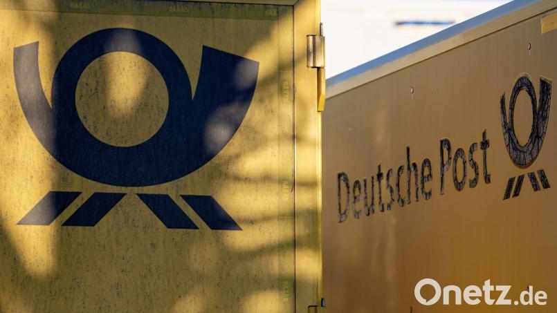 Das gute alte Posthorn, das Logo der Deutschen Post - hier an Lastwagen, die vor einem Kölner Briefzentrum parken. Bild: Henning Kaiser/dpa
