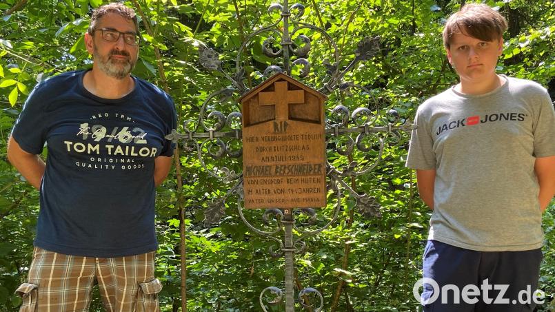 Jürgen Berschneider und Sohn Moritz vor der Gedenktafel für den vom Blitz erschlagenen (Groß)onkel Michael. Das Kreuz steht am Kreuzweg von Ensdorf zum Eggenberg. Bild: Andreas Ascherl