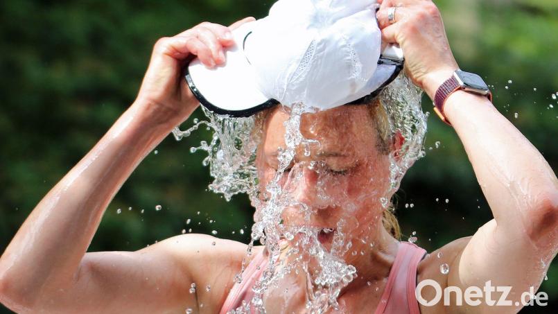 Eine Läuferin erfrischt sich an einer Wasserstelle. (Archivbild) Bild: Markus Tischler/dpa