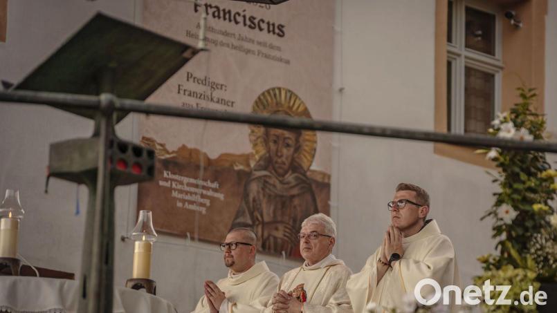 Der Heilige Franziskus im Bildhintergrund wachte als Plakat am Freialtar und thematisch während der Festwoche über seine Amberger Brüder: die Patres Clemens Swierz (rechts) und Seraphin Broniowski (links). Bild: Michael Golinski