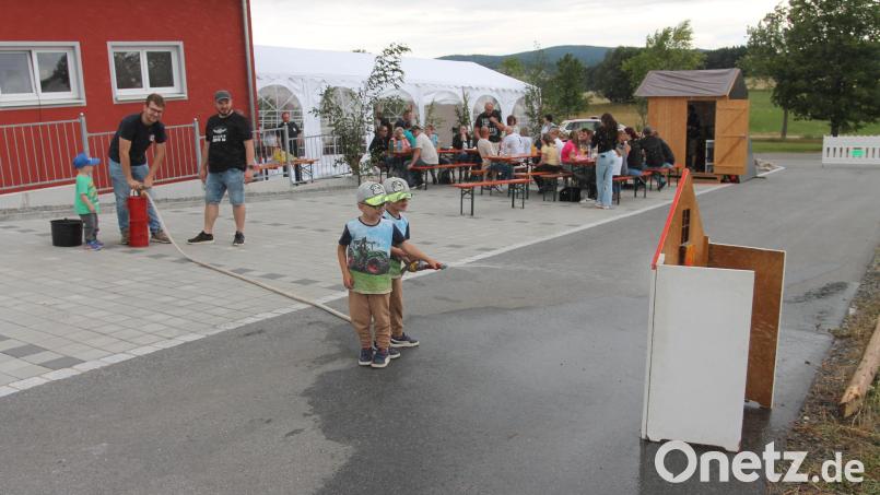 "Wasser marsch!" Kommandant Konstantin Völkl pumpt, und die Kinder haben ihren Spaß an der Kübelspritze. Bild: Josef Pilfusek