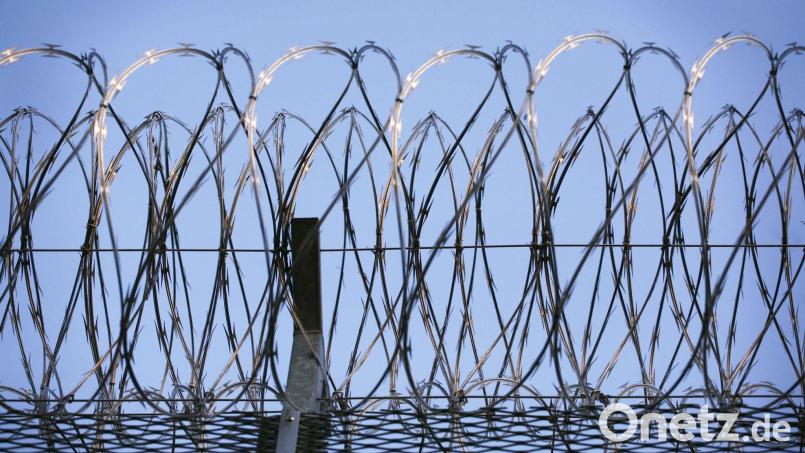 Stacheldraht krönt den Zaun eines Gefängnisses. In Landshut verhindert eine Spezialeinheit der Polizei die Befreiung eines Gefangenen. Symbolbild: Wolfram Steinberg/dpa