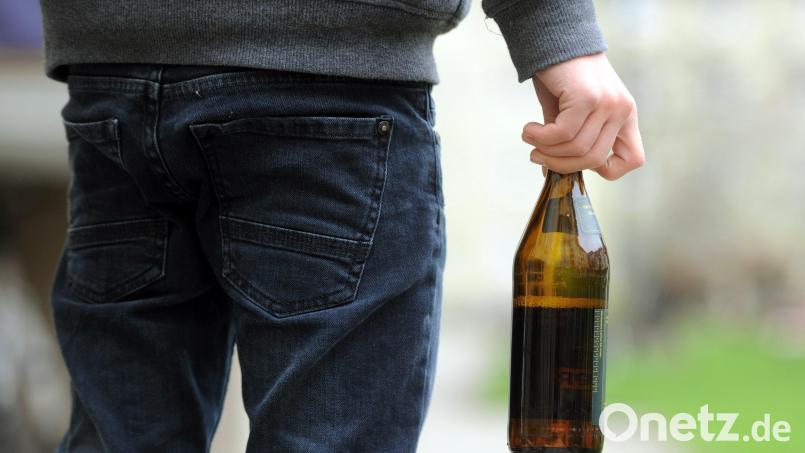 Eine Person hält eine geöffnete Bierflasche in der Hand. In Regensburg hat ein 29-Jähriger mit einer geworfenen Flasche eine Frau im Gesicht verletzt. Symbolbild: Tobias Hase /dpa