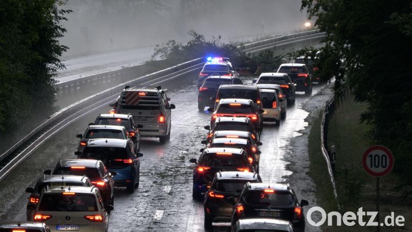 Die Polizei leitet den Verkehr auf der Bundesstraße 4 bei Erlangen-Tennenlohe an umgestürzten Bäumen vorbei. Bild: Bernd März/Fotoreportextremwetter.tv/dpa