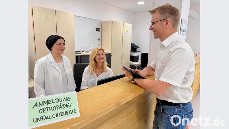 Der kaufmännische Leiter des MVZ im Klinikum Weiden Lars Bergmann (rechts), Gynäkologin Dr. Nancy Ahmed (links) und Praxismanagerin Sandra Bergmann am neuen zentralen Anlaufpunkt der Gynäkologie und Orthopädie. Davon sollen sowohl Patientinnen und Patienten als auch das Personal profitieren. Bild: Gabi Schönberger