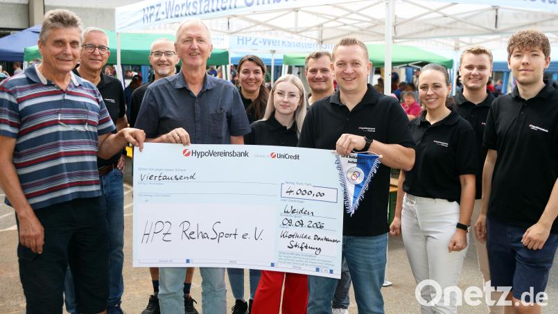 Christian Wolf (Vierter von rechts) und sein „Werkstattfest-Team“ überreichen den Scheck an Max Hohlrüther (links) und Thomas Fritsch (vorne Zweiter von links). Bild: Stephan Landgraf