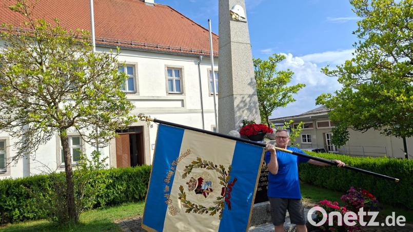 Vorsitzender der Soldaten- und Kriegerkameradschaft (SKK) Mähring Reinhard Beer mit der neu restaurierten Vereinsfahne am Ehrenmal. Bild: Reinhard Beer
