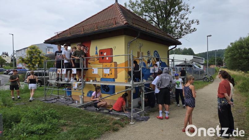 Werken-Lehrerin Katharina Zaiß (rechts, rotes Shirt) ist zufrieden mit ihren Nachwuchs-Künstlern: 26 Schülerinnen und Schüler der Realschule haben das Pumpstationhaus vielfältig bemalt. Bild: Tobias Gräf