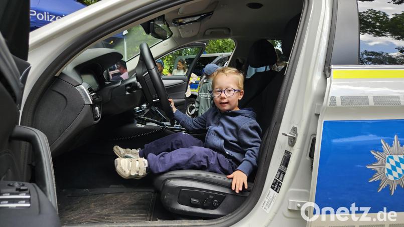 Der fünfjährige Moritz Frischmann aus Pleystein ist stolz darauf, im Polizeiauto am Steuer Platz nehmen zu dürfen. Auch das Polizeimotorrad wollte er beim Kinderbürgerfest in Weiden unbedingt noch erklimmen. Bild: Sonja Kaute