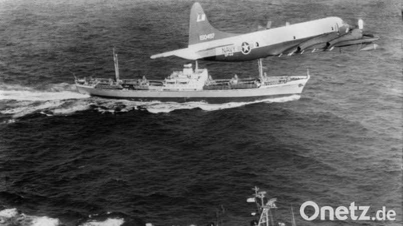 Ein Aufklärungsflugzeug der US-Marine fliegt während der Kubakrise vor der Küste Costa Ricas über das US-Kriegsschiff „USS Barry“ (vorne) und den sowjetischen Frachter „Anosow“. (Archivbild) Bild: picture alliance / dpa