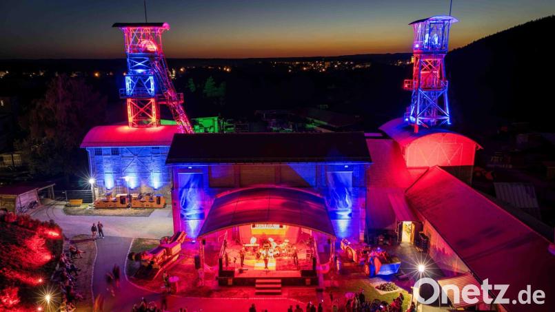 Das Classic-Rock-Festival G:O:A findet auf dem Gelände des Bergbaumuseums Maffeischächte statt. Neben der Bühnenbeleuchtung werden in der Dämmerung auch die Fördertürme illuminiert. Bild: Michel Grüner / Förderverein Maffeispiele