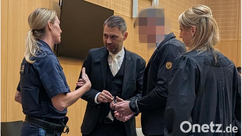 Vor Beginn des sechsten Verhandlungstags löst eine Vorführbeamte den Angeklagten im Müllprozess die Handschellen. Die Verteidiger Stefanie Amann und Rouven Colbatz hätten gerne, dass der 53-Jährige dem Prozess künftig dauerhaft ohne Fesseln folgen kann. Bild: wüw