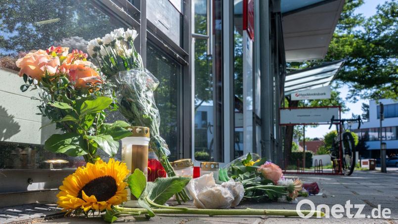 Menschen legten nach dem tödlichen Angriff Blumen und Kerzen vor der Filiale ab. Bild: Armin Weigel/dpa