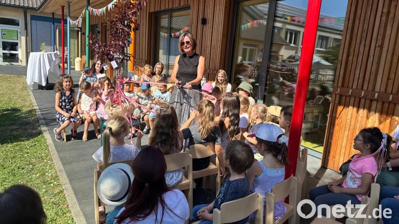 Inmitten der Kinderschar schneidet Anette Zwack das Band durch, das symbolisch den Eintritt in den Ruhestand darstellt. Bild: Richard Brunner
