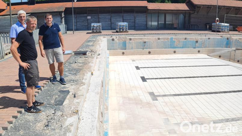 Nicht nur das Wasser im Schwimmerbecken ist weg, auch die Startblöcke sind abgebrochen worden. Dritter Bürgermeister Reinhold Kastner sowie Markus Meyer und Sebastian Kraus (von links) vom Bauamt machen sich ein Bild vom Stand der Sanierungsarbeiten. Bild: luk