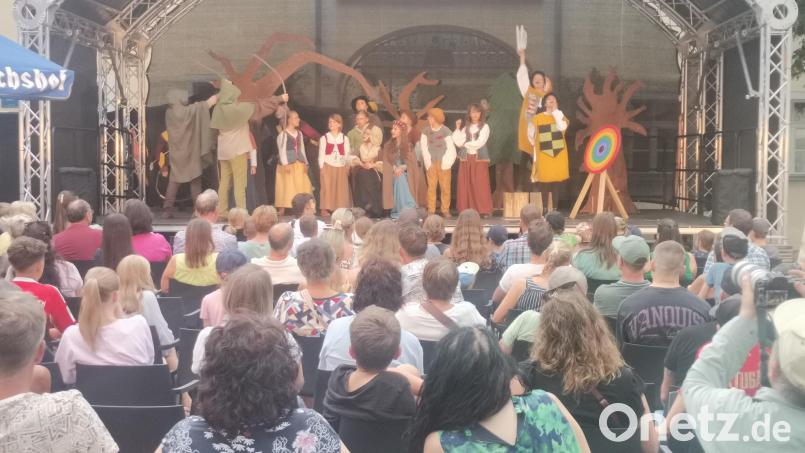 Der verkleidete Robin Hood (gespielt von Elisa von Stern) trifft unter Anfeuerung seiner Freunde ins Schwarze. Bild: Annemarie Mösbauer
