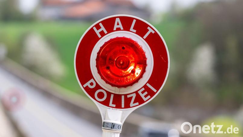 Der Polizist versuchte unter anderem mit einer Leuchtkelle, den Wagen anzuhalten. (Symbolbild) Bild: Armin Weigel/dpa