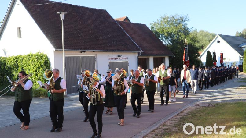 Der Festzug, angeführt von der Blaskapelle Ensdorf, zog am sanierten alten Gerätehaus (links) der Feuerwehr Wolfsbach vorbei, in dem sich der künftige Stellplatz des neuen Mannschaftstransportwagens befindet. Bild: Michael Rabenhofer