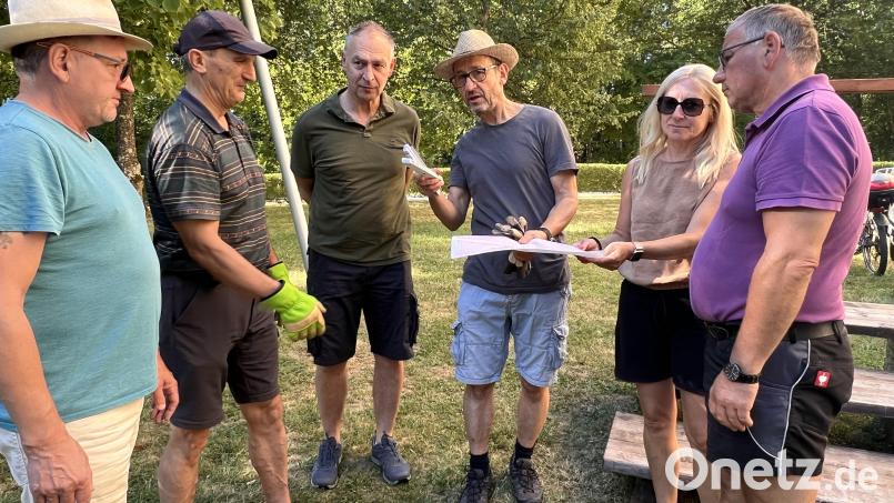Josef Koch (Mitte) bespricht als Gesamtverantwortlicher mit freiwilligen Helfern den Aufbauplan der Bänke . Bild: Marianne Moosburger