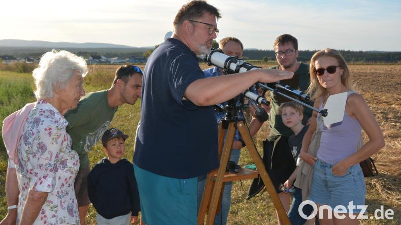 Peter Postler (Mitte), Leiter der Sternwarte Tirschenreuth, erklärt den Besuchern die Funktion des Teleskops. Bild: Josef Rosner