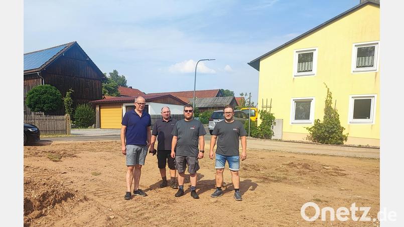 Bürgermeister Roman Schäffler, Kommandant Matthias Reger, sein Stellvertreter Thorsten Lottes und Zweiter Vorsitzender Lukas Ohlinger (von links) auf dem Areal, auf dem das neue Feuerwehrgeräte- und Dorfgemeinschaftshaus entstehen soll. Im Hintergrund (gelbes Gebäude) ist das bisherige Domizil der Brandschützer zu sehen, das nicht mehr den Anforderungen an eine moderne Wehr entspricht. Bild: luk