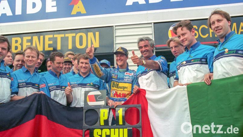 Formel-1-Pilot Michael Schumacher (Mitte) jubelt 1994 mit seinem Benetton-Team über seinen WM-Titel. (Archivbild) Bild: Harry Melchert/dpa