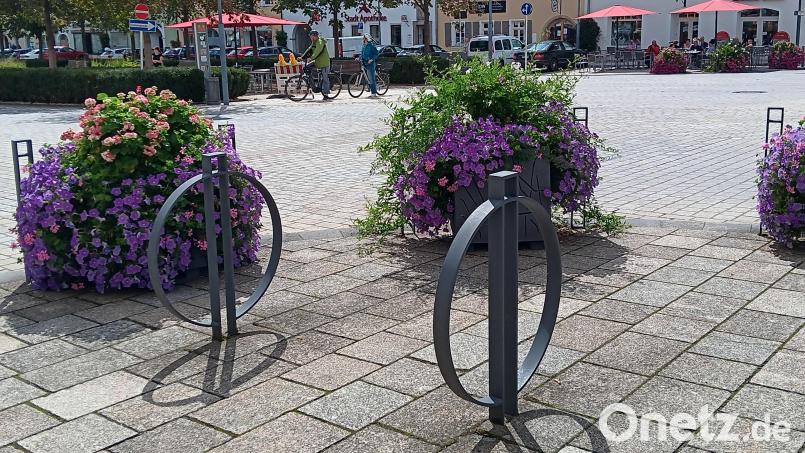 Die Fahrradstellplätze bei der Sparkasse, im Hintergrund zwei Radfahrer. Bei diesen ist der Marktplatz besonders an schönen Tagen ein beliebtes Ausflugsziel. Bild: as