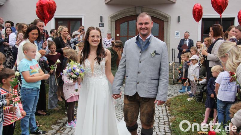 Frisch verheiratet: Freudestrahlend durchschreiten Celina und Patrick Sporrer das Ehrenspalier. Bild: Konrad Rosner