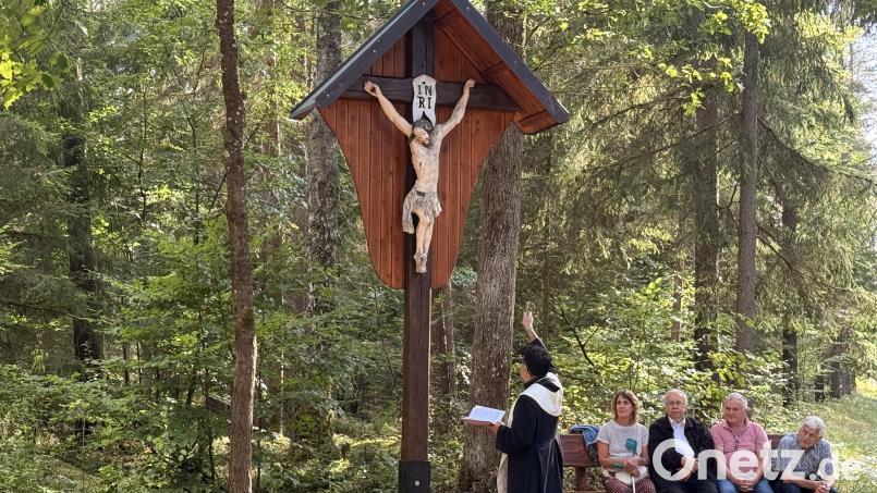 Pater Ivo weiht das Eicherne Kreuz im Bürgerwald. Das Kreuz war im Frühjahr wohl durch einen Sturm stark beschädigt und nun repariert worden. Bild: Heidi Kurz
