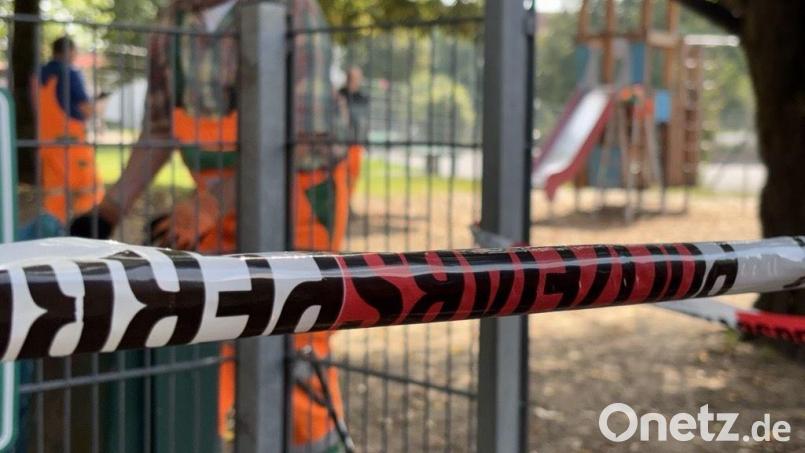 Ein Polizeiabsperrband zeigt am Mittwochvormittag, dass der Spielplatz an der Hans-Thoma-Straße nicht benutzt werden darf. Im Hintergrund arbeiten Angestellte des Betriebshofs an der Wiederherstellung der mutwillig beschädigten Spielgeräte. Bild: roa
