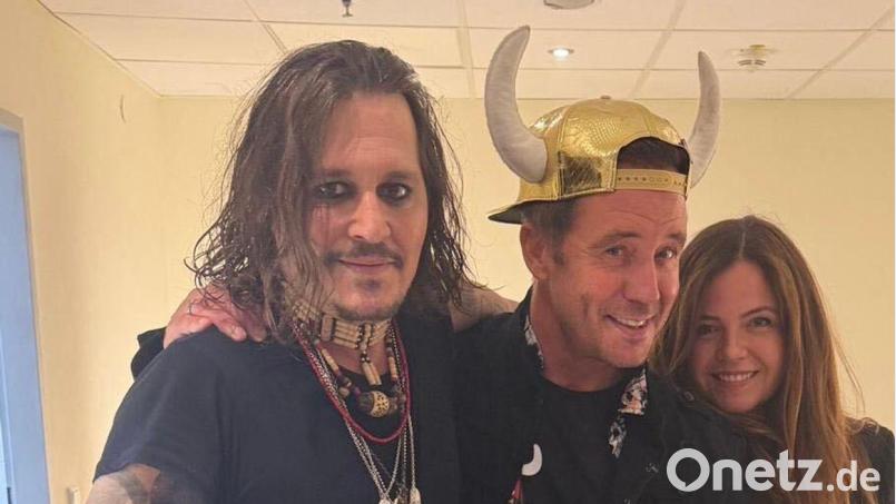 Büffel überreichte seinem großen Idol Johnny Depp in der Künstlergarderobe seine Platin-Schallplatte. (Handoutbild) Bild: ---/Lorenz Büffel/dpa