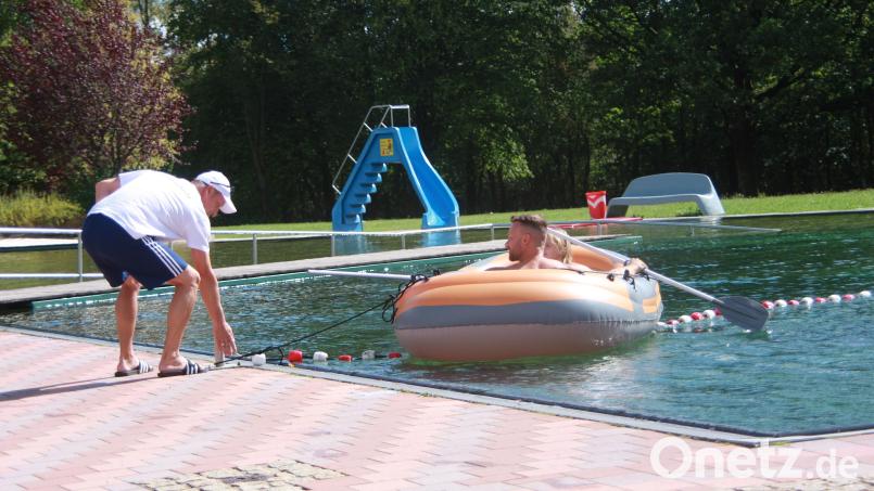 Betriebsleiter und Bademeister Kai Wolf (links) lässt im Naturbadesee bei Immenreuth ein Schlauchboot zu Wasser. Bild: Werner Robl