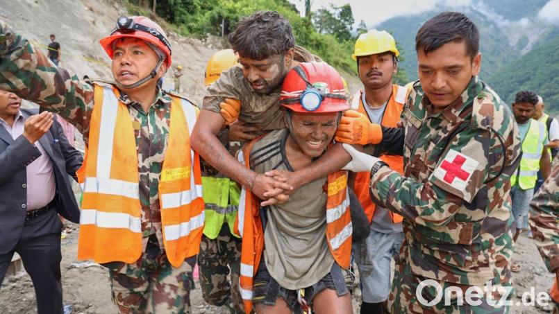Ein geretteter Mann wird von Bergungskräften getragen. Bild: Uncredited/Nepal Army/AP/dpa