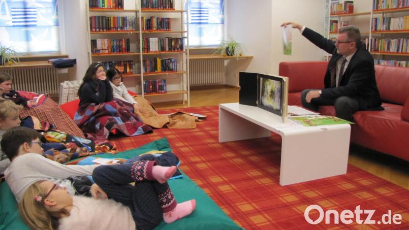 Bürgermeister Michael Göth stimmt die Kinder in der Stadtbibliothek mit dem Märchen "Das Tannenbäumchen" auf Weihnachten ein Bild: cog