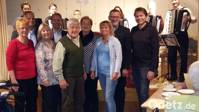 Die Geehrten mit den Laudatoren von links nach rechts Angela Hecht, Dr. Seitz, Marianne Neudert, Stefan Schmiedberger, Norbert Fleißner, Gertrud Hecht, Kathrin Dietz, die Leiterin für soziale Betreuung, Stadtpfarrer Thomas Vogl und Heimleiter Bernhard Riedl. Im Hintergrund die Musikanten der Kreismusikschule Tirschenreuth mit Alois Fischer (rechts). Bild: kdi