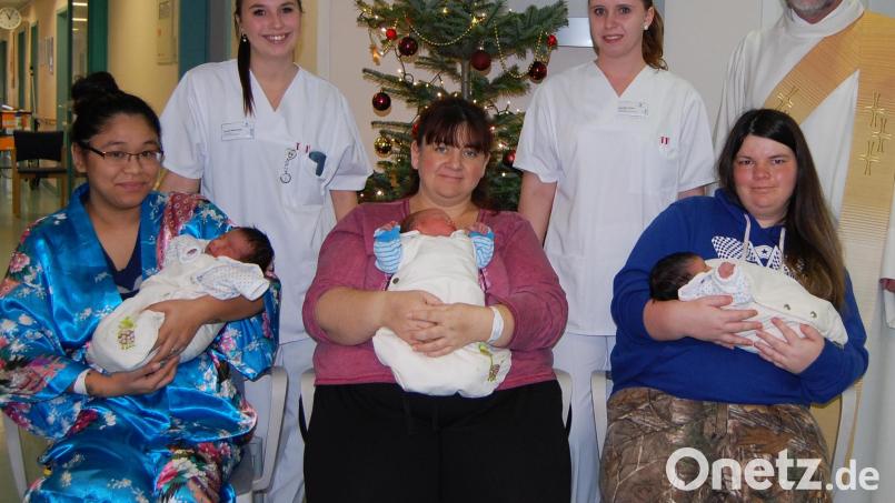 Gleich drei Christkinder erblicken an Heiligabend in Amberg das Licht der Welt. Von links: Courtney Renee Dickerson mit Elaina, Regina Jobst mit Lorenz und Audrey May Cervantes mit Joseph Albert. Mit ihnen freuten sich Janet Hofmann, Jennifer Dorn (Station B2) und Klinikseelsorger Peter Bublitz (hintere Reihe, von rechts). Bild: Verena Uschold, Klinikum St. Marien