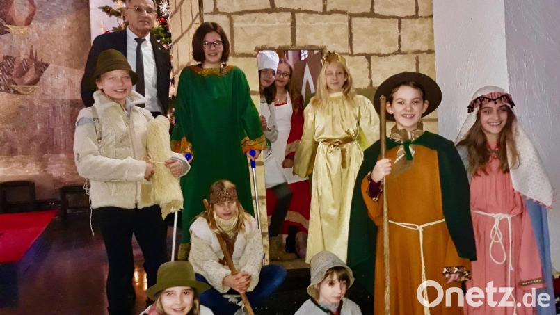 Karl Koller (hinten, links) hat mit zehn Mädchen ein stimmungsvolles Krippenspiel einstudiert. In der Kinderchristmette in der vollbesetzten Pfarrkirche spielen sie stimmungsvoll die Herbergssuche. Bild: ise