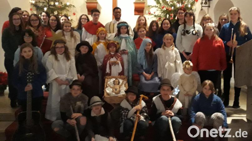 Im Mittelpunkt der kleinen Andacht an Heiligabend steht natürlich das Jesukind in der Krippe. Rund 40 Kinder und Jugendliche gestalten mit Pfarrvikar Justin Kishimbe den Wortgottesdienst in der voll besetzten Herz-Jesu-Pfarrkirche. Bild: mez