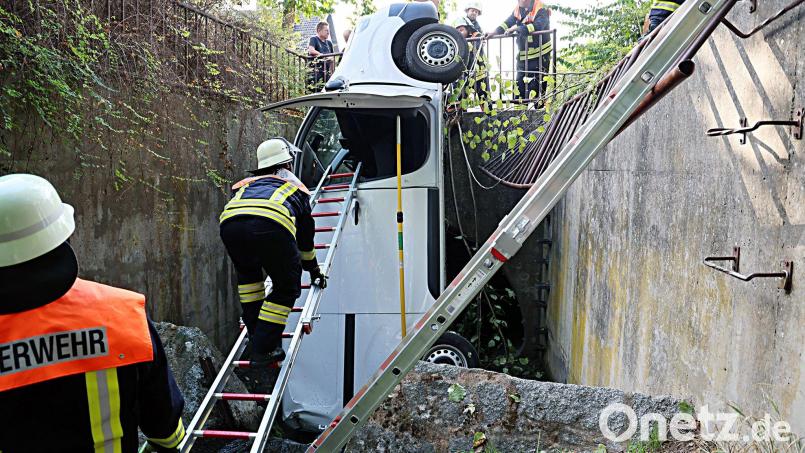 Ein Transporter durchbricht ein Metallgeländer und landet senkrecht im Bach. Bild: Ralf Hettler/dpa