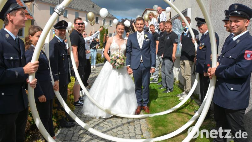 Es ist immer sehenswert, wenn ein Brautpaar durch die Feuerwehrschläuche steigt und die Glückwünsche der Feuerwehr entgegen nehmen darf. Lea und Matthias Schedl genossen dieses sichtlich. Bild: Josef Rosner