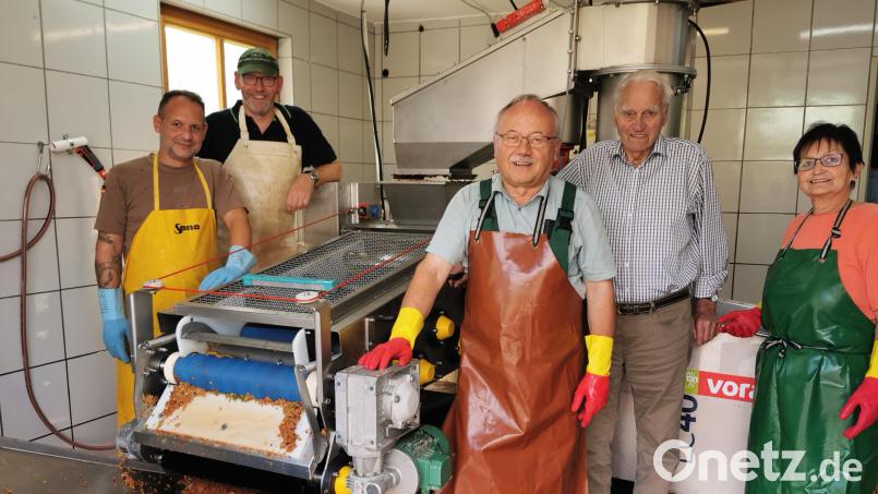 An der Bandpresse: OGV-Vorsitzender Karl Ruhland (Mitte) freut sich mit seinem Team (von links: Stefan Ruhland, Martin Fischer und Rita Forster) über das Jubiläum "40 Jahre Obstpressen". Adolf Uschold (Zweiter von rechts) hatte die erste Anlage in Betrieb genommen. Bild: Gertraud Portner