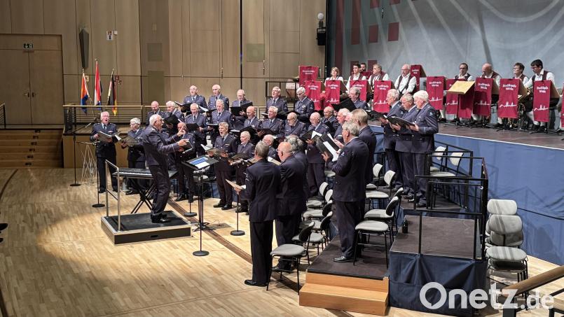 17 Musiker der Weidener Stadtkapelle und 34 Sänger des Königlichen Niederländischen Luftwaffen-Chors bei ihrem großen Auftritt auf der voll besetzten Bühne der Weidener Max-Reger-Halle. Bild: Martin Gollwitzer
