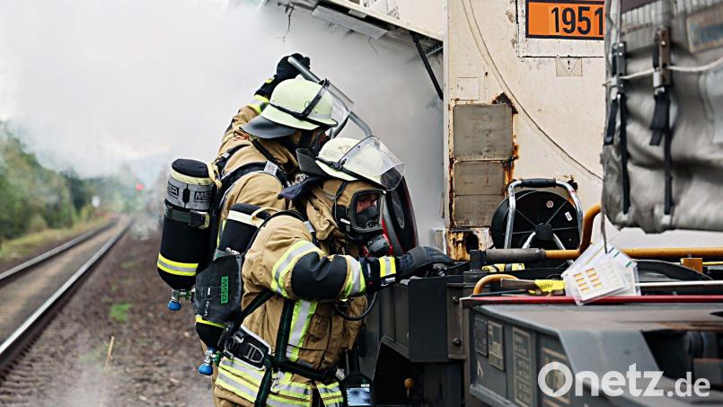 Unter Atemschutz versuchten Feuerwehrleute, den Gasaustritt am Waggon zu stoppen. Bild: Ralf Hettler/dpa