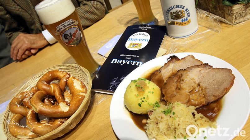 Schweinebraten mit Knödel: Bürgermeister Reinhard Kreuzer legt Wert darauf, dass dieses Leibgericht mit bayerischer Tradition angesichts neuer Trends in Schönsee nicht ins Hintertreffen gerät. Bild: Wolfgang Kumm/dpa