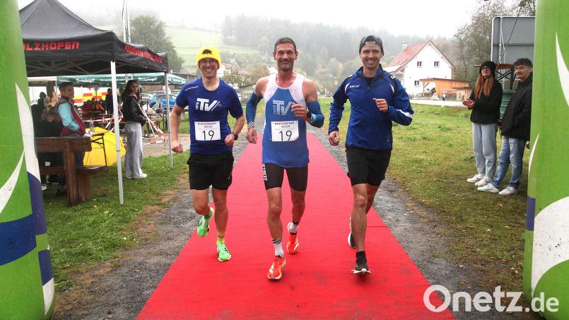 Der Schlussläufer der Siegerstaffel TV Burglengenfeld, Markus Gleißl (Mitte), ließ sich beim Zieleinlauf von zwei Mannschaftskollegen begleiten. Bild: Rudolf Hirsch