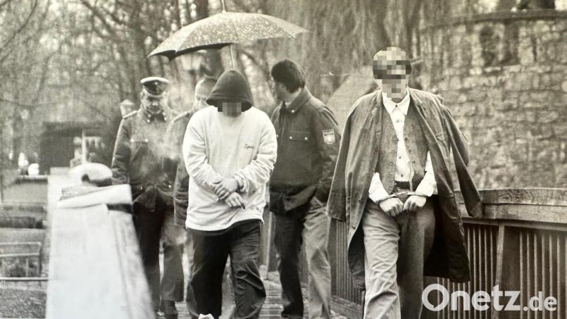 In Begleitung von Polizisten werden die beiden Täter bei einer Tatortbegehung zurück zum Vilssteg in Amberg gebracht. Archivbild: Alexander Unger