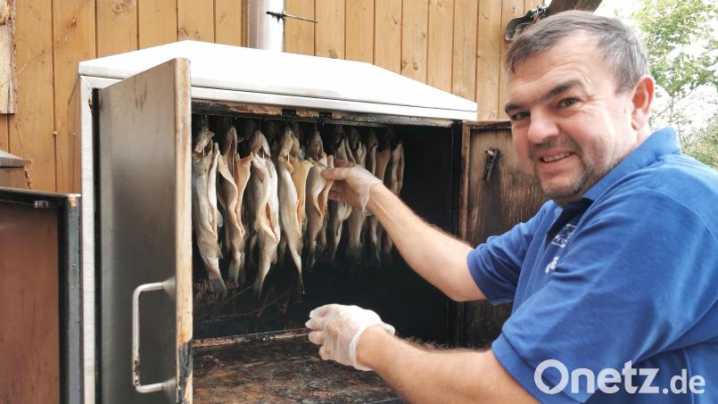 Stephan Gäbl aus Teunz bestückt den Räucherofen im Garten mit frischen Forellen. Bild: Gertraud Portner