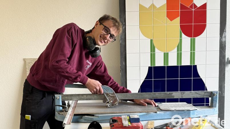 Tim Götz liebt die Tätigkeit als Fliesenleger. Für den 18-Jährigen Vilshofener geht es aktuell auf die Meisterschule nach Straubing. Im Hintergrund ist eines seiner Werkstücke zu sehen, die in der Begabtenförderung entstanden sind. Bild: Jasmin Götz