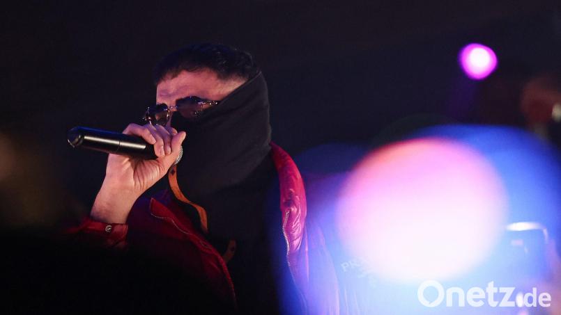 Haftbefehl verdeckt sein Gesicht bei einem Auftritt in Gießen mit einem Tuch. (Archivbild) Bild: Hannes P. Albert/dpa